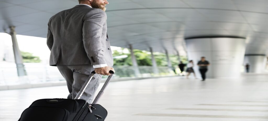 Un uomo con in mano una valigia che viaggia per affari grazie a viaggi nel risparmio